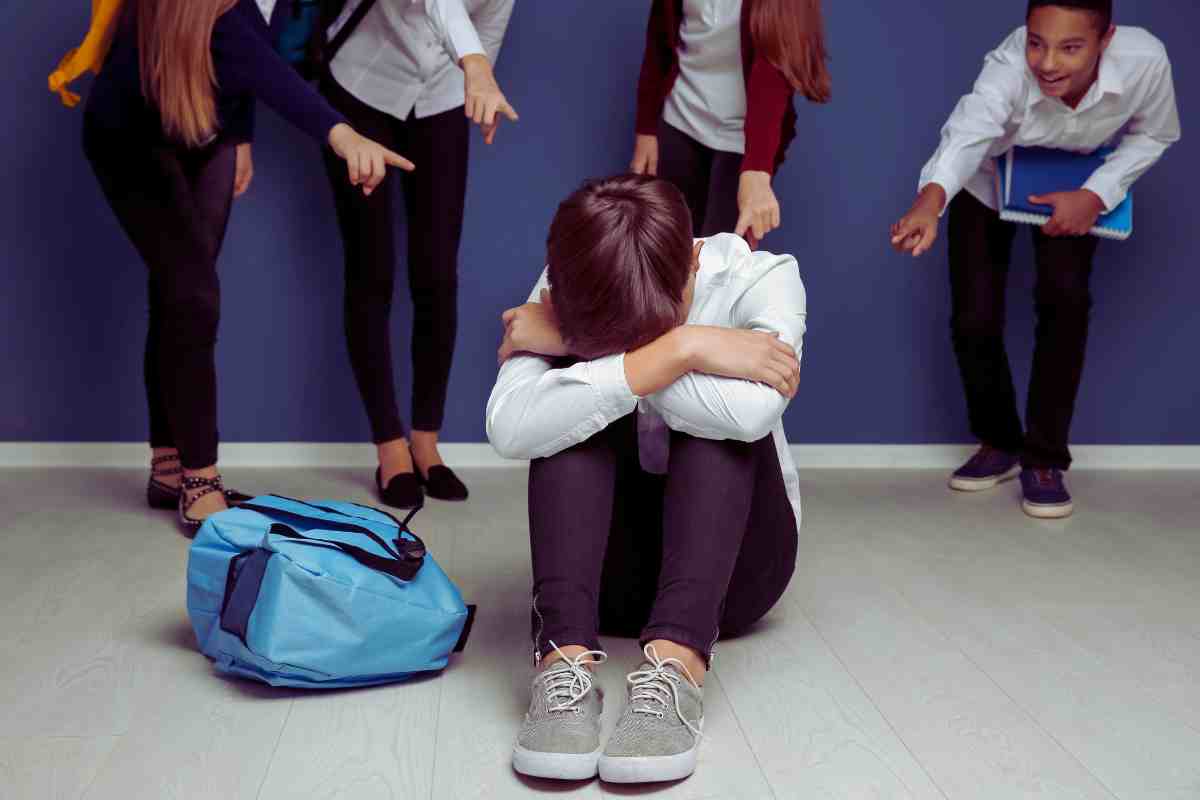 ragazzo seduto a terra con le braccia sulle ginocchia